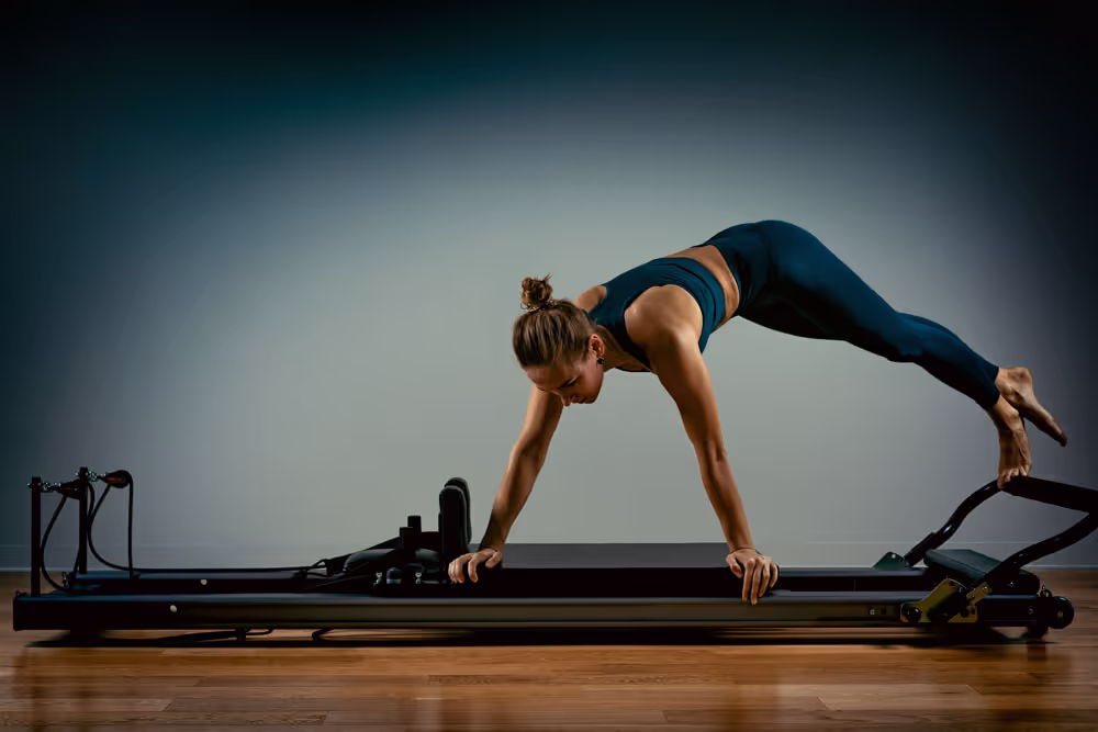 A woman exercises on a Pilates machine